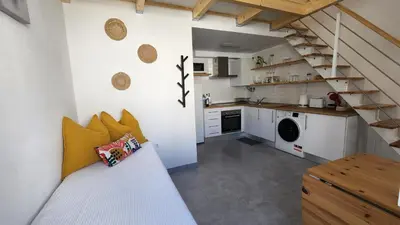 a small kitchen with a staircase in a room at Tiny House Faro in Faro