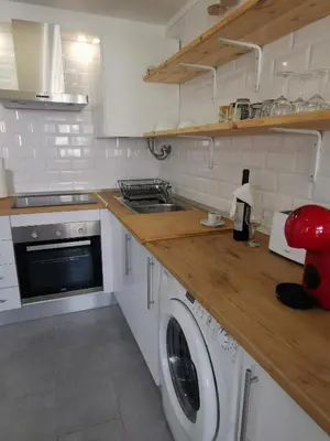 a kitchen with a washer and a washing machine at Tiny House Faro in Faro