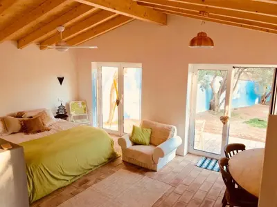 a bedroom with a bed and a chair and windows at Casa De Mondo in Boliqueime