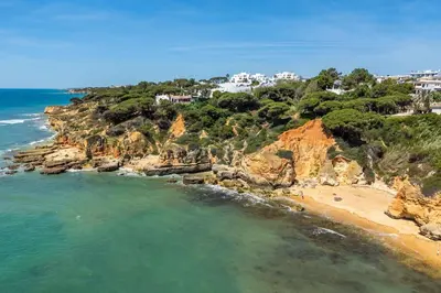 an aerial view of a beach with houses on a cliff at T2 Eucalipto 2A by Algarneto in Olhos de Água