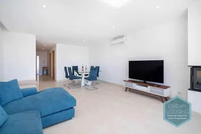 a living room with a blue couch and a flat screen tv at Patroves Sea View - Dream Lodging in Albufeira