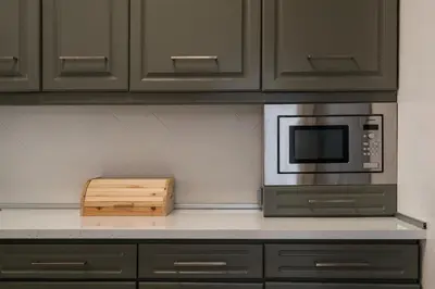 a kitchen counter with a microwave and a wooden box at Villa Macuti by SAPvillas in Vilamoura