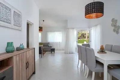 a kitchen and living room with a table and chairs at Villa Macuti by SAPvillas in Vilamoura