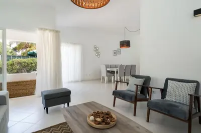 a living room with a table and chairs at Villa Macuti by SAPvillas in Vilamoura