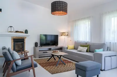 a living room with a couch and a tv at Villa Macuti by SAPvillas in Vilamoura