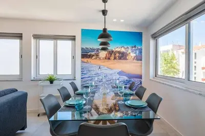 a dining room with a glass table and chairs at Central Town 2-Bedroom Apartment Albufeira in Albufeira