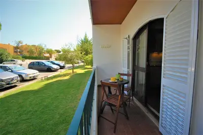 a balcony with a table and a view of a parking lot at T0 Estudio Leziria - Swimming pool in Vilamoura