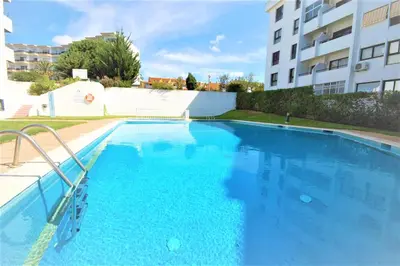 a swimming pool in front of a building at T0 Estudio Leziria - Swimming pool in Vilamoura