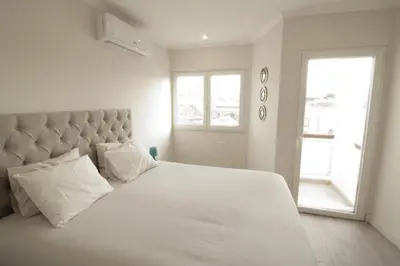 a bedroom with a large white bed and a window at Downtown Dreams in Faro