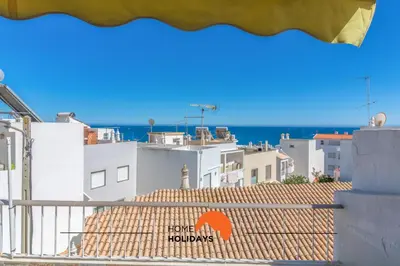 a view of the roofs of buildings and the ocean at #057 T1 Rossio 43D by Home Holidays in Albufeira