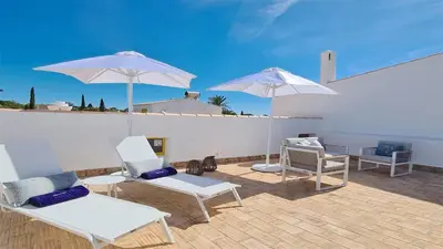 a patio with white chairs and umbrellas at Vila Chez Lee, 219 Aldeia do Golf-CleverDetails - Sleeps 6, quiet area in Vilamoura