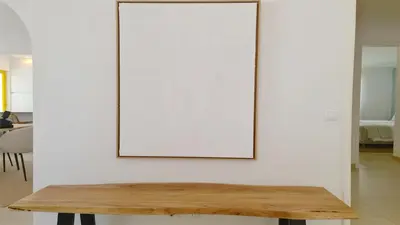 a picture frame on a white wall with a wooden table at Vila Chez Lee, 219 Aldeia do Golf-CleverDetails - Sleeps 6, quiet area in Vilamoura