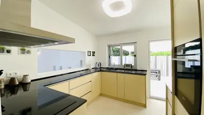 a kitchen with white cabinets and a large window at Moderna by Check-in Portugal in Quarteira