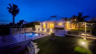 a house with a swimming pool at night at Moderna by Check-in Portugal in Quarteira