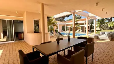 a dining room with a table and chairs and a pool at Seventies by Check-in Portugal in Quarteira