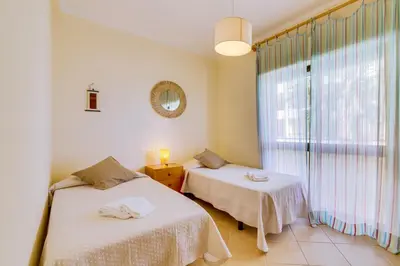 two beds in a room with a window at InfiniteSeaView - Quarteira at Homesbyfc in Quarteira