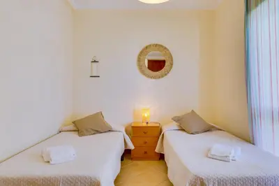 two twin beds in a room with a mirror at InfiniteSeaView - Quarteira at Homesbyfc in Quarteira