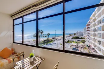 a room with a view of the beach from a window at InfiniteSeaView - Quarteira at Homesbyfc in Quarteira