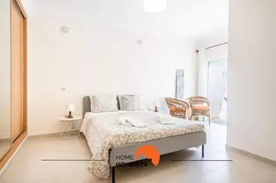a bedroom with a bed with an orange arrow pointing to a home horizons at #055 São José V by Home Holidays in Albufeira