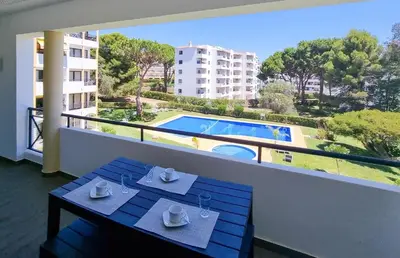 a balcony with a table and a view of a pool at FLH Vilamoura Summer Flat with Pool in Vilamoura