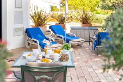 a patio with chairs and a table with food on it at Casa Alessa - Vale de Lobo in Almancil
