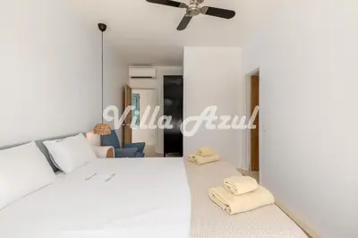 a bedroom with a white bed and a ceiling fan at Elegant villa with private pool in Quarteira in Vilamoura