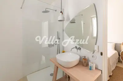 a bathroom with a sink and a shower and a mirror at Elegant villa with private pool in Quarteira in Vilamoura