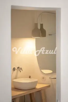 a bathroom with a white sink and a mirror at Elegant villa with private pool in Quarteira in Vilamoura