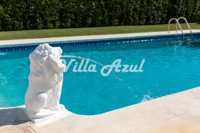 a statue of a mermaid sitting next to a swimming pool at Elegant villa with private pool in Quarteira in Vilamoura