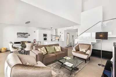 a living room with couches and chairs and a kitchen at ELLE Design Villa by OCvillas - Private Heated Pool and Jacuzzi in Albufeira
