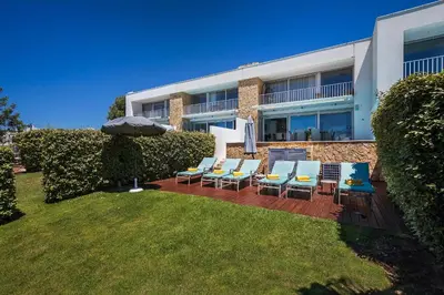 a group of chairs and an umbrella on a patio at ELLE Design Villa by OCvillas - Private Heated Pool and Jacuzzi in Albufeira