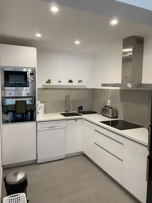 a white kitchen with a sink and a microwave at Beira mar in Albufeira
