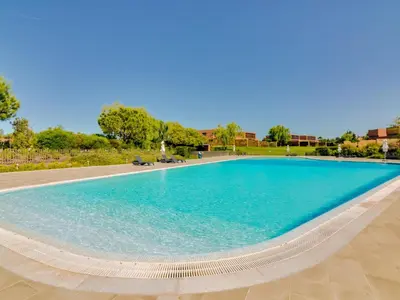 a large swimming pool with blue water at L'orangerie modern 1bdr apartment, ground floor in Vilamoura