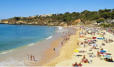 a crowd of people on a beach with the ocean at Appartement T1 Albufeira Strip Oura in Albufeira