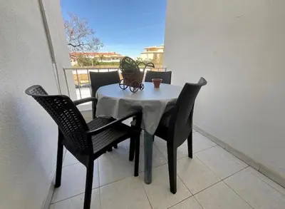 a table and chairs on a balcony with a plant on it at Appartement T1 Albufeira Strip Oura in Albufeira
