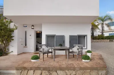 a patio with a table and chairs in front of a house at Casa Estrela do Mar in Vale do Lobo