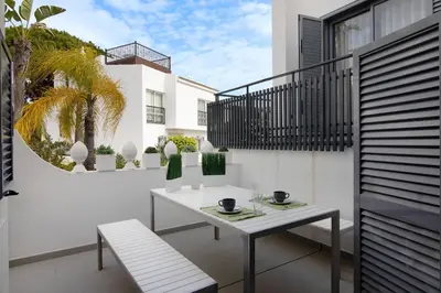 a white table and bench on a balcony at Casa Estrela do Mar in Vale do Lobo