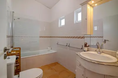 a white bathroom with a sink and a toilet at Casa Estrela do Mar in Vale do Lobo
