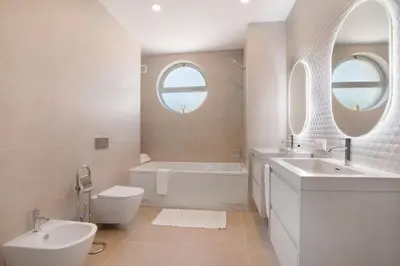 a white bathroom with a tub and a sink and a toilet at Casa Valerie in Vale do Lobo
