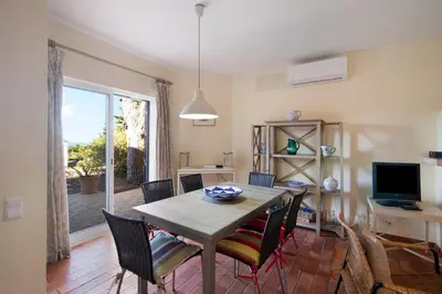 a dining room with a table and chairs and a window at Casa Allan in Vale do Lobo
