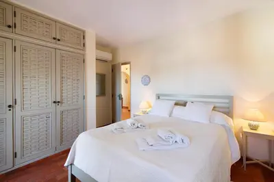 a bedroom with a white bed with towels on it at Casa Allan in Vale do Lobo