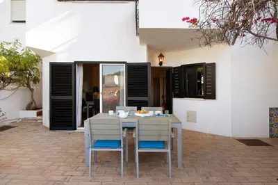 a dining table and chairs on a patio at Casa Allan in Vale do Lobo