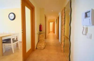 a hallway with a table and a clock on a wall at Perfect New Apartment in Albufeira in Albufeira
