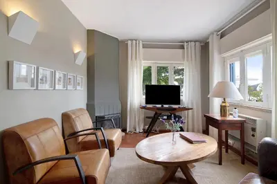 a living room with a table and a television at Villa Apfel in Vale do Lobo