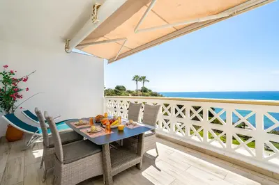 a dining table with a view of the ocean at Aveiros by the Sea by Intiholidays in Albufeira