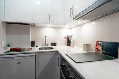 a kitchen with white cabinets and a sink at Aveiros by the Sea by Intiholidays in Albufeira