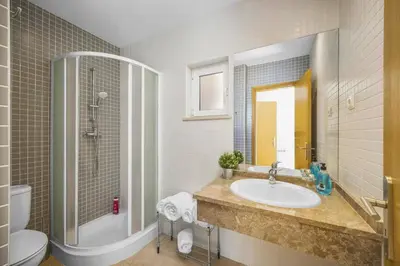 a bathroom with a sink and a shower and a toilet at Villa Falesia Blue by Villa Plus in Olhos de Água