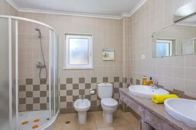 a bathroom with a toilet and a sink and a shower at Villa Falesia Blue by Villa Plus in Olhos de Água