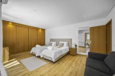 a bedroom with a large white bed and a couch at Villa Falesia Blue by Villa Plus in Olhos de Água