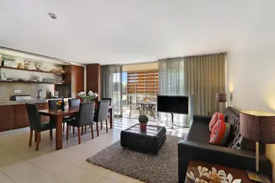 a living room with a couch and a dining room at Salgados 4seasons Apartment in Albufeira